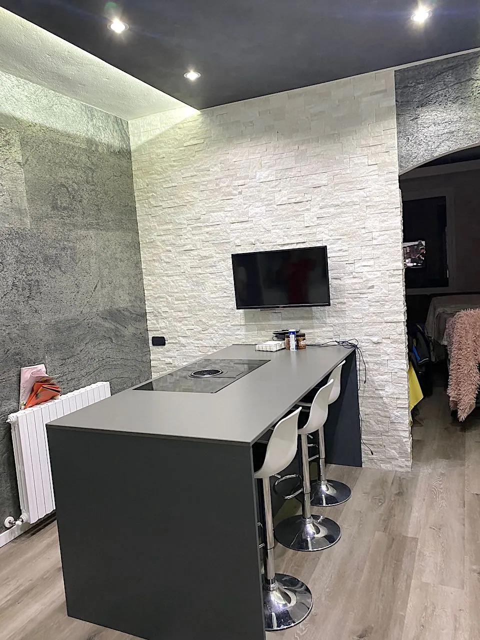 Parete interna rivestita in quarzite bianca con cucina a isola